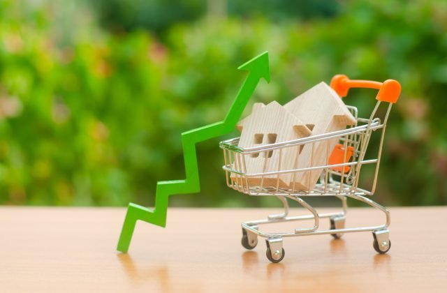 Two wooden houses in a trading cart and green arrow up